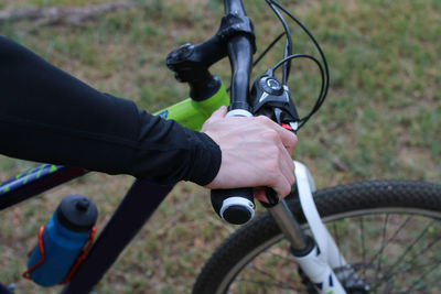 Cropped hand of man riding bicycle at park