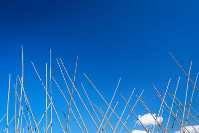 Low angle view of metallic pole against clear blue sky