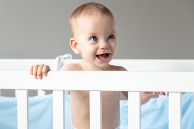 Portrait of cute baby boy lying on bed at home