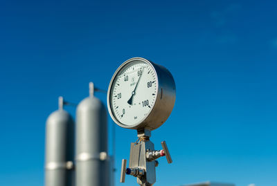 Low angle view of security camera against blue sky