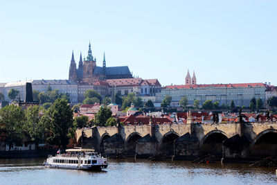 Bridge over river against buildings in city