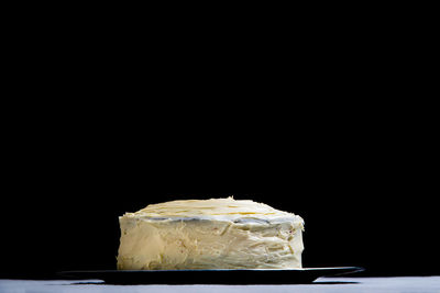 Close-up of bread on table against black background