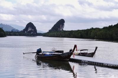 Boat moored on lake against sky