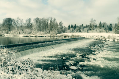 Scenic view of lake against sky during winter