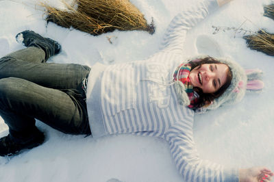 High angle view of woman sitting on snow. cheerful girl teenager in a funny hat is lying. laughing.