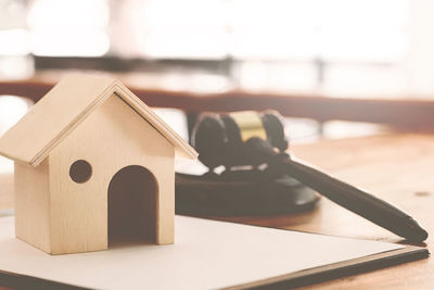 Close-up of model house and gavel on table