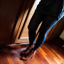 Low section of woman standing on hardwood floor