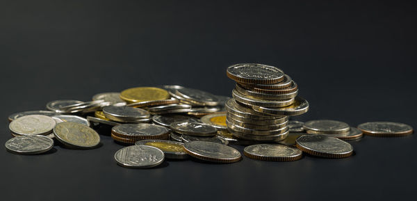 Stack of coins on table against black background