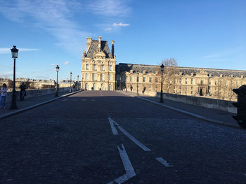 Road by building against sky in city
