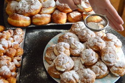 Close-up of hand powdering donuts