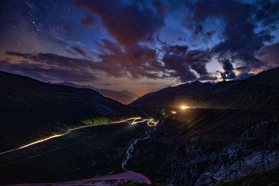 Road by mountain against sky at night