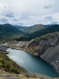 Scenic view of river and mountains against sky