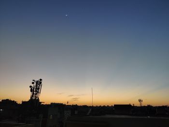 Silhouette city against sky during sunset