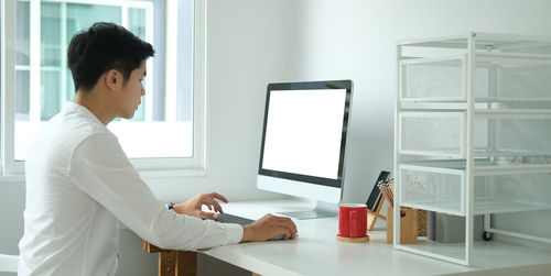 Side view of businessman using computer on desk