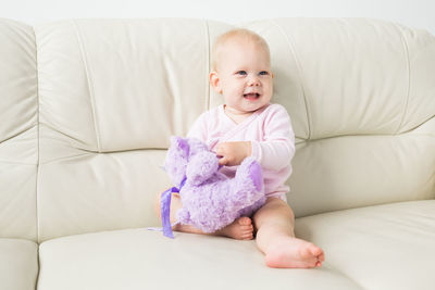 Portrait of cute baby girl on sofa