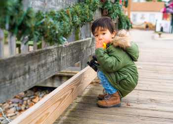 Portrait of cute baby boy on bridge