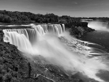 Scenic view of waterfall against sky