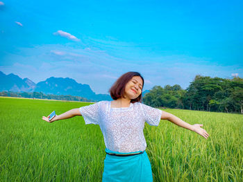 Full length of young woman standing on field