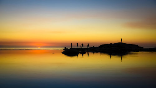 Silhouette of boats in sea at sunset