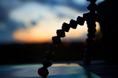 Close-up of chain against sea during sunset