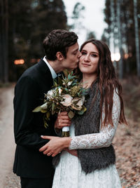 Young couple standing against wall