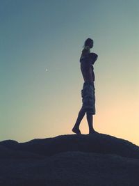 Silhouette of woman against clear sky