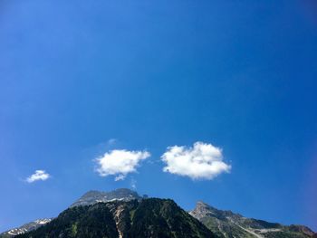 Low angle view of mountain against blue sky