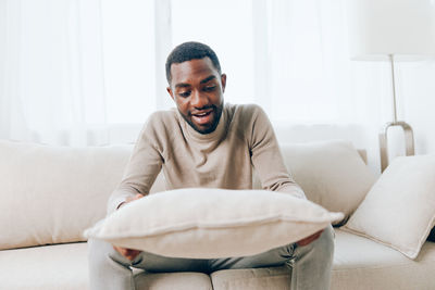 Young woman using laptop while lying on sofa at home