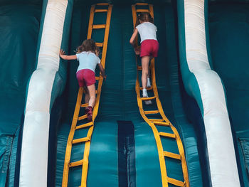 Rear view of women standing at swimming pool