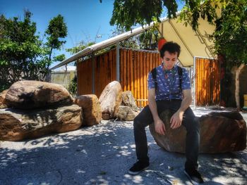 Full length of man sitting on rock