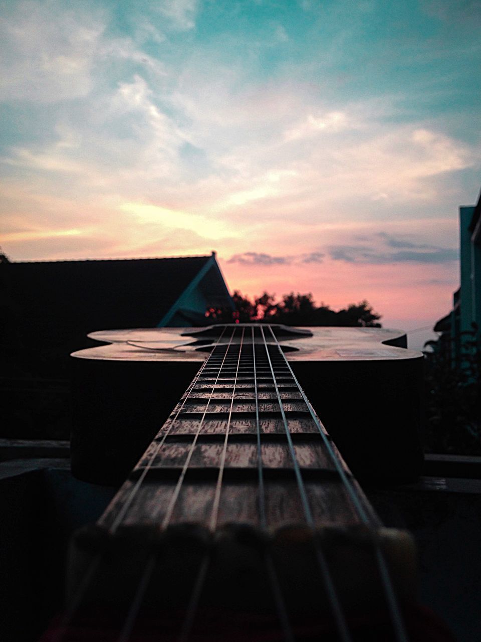 CLOSE-UP OF GUITAR AGAINST SKY