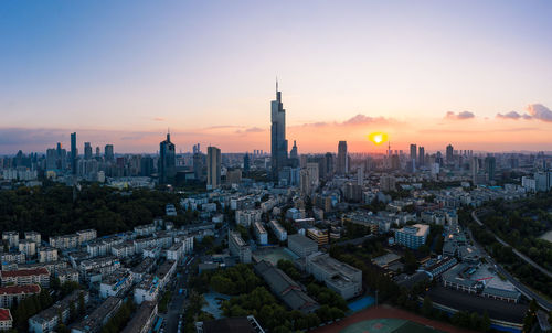 Aerial view of buildings in city at sunset