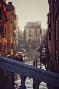 Canal amidst buildings in city against clear sky