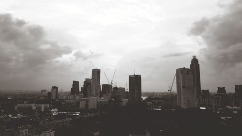 View of cityscape against cloudy sky