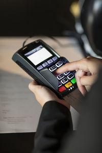 Close-up of hands holding credit card reader