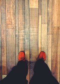 Low section of man standing on hardwood floor