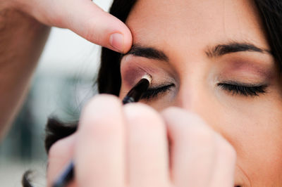 Woman applying eyeshadow on friend eye