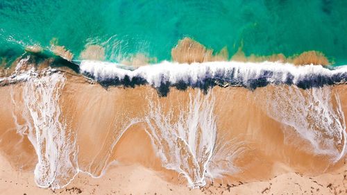 High angle view of surf on sea shore