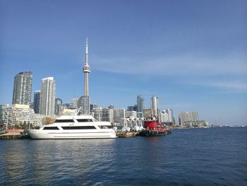 Modern buildings by sea against sky in toronto ships at dock