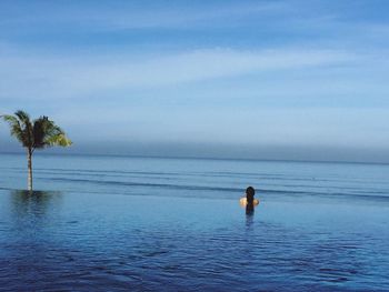 Man in sea against sky