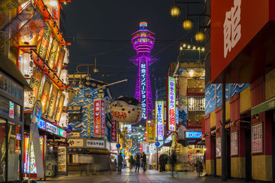 Low angle view of illuminated street lights in city at night