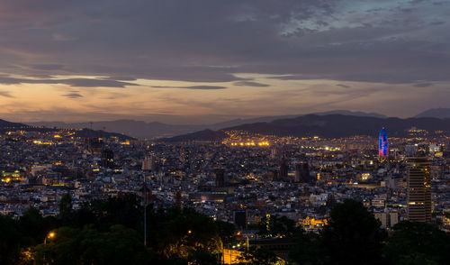 Illuminated cityscape against sky at night