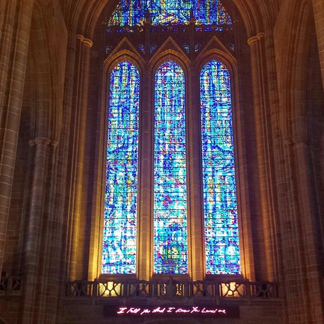indoors, religion, place of worship, church, spirituality, stained glass, window, architecture, design, low angle view, built structure, pattern, multi colored, ornate, glass - material, cathedral, illuminated, ceiling
