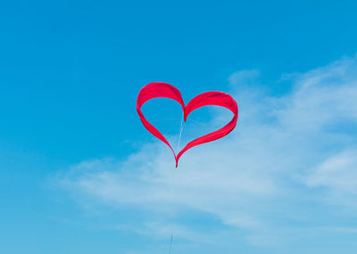 Low angle view of balloons against clear blue sky