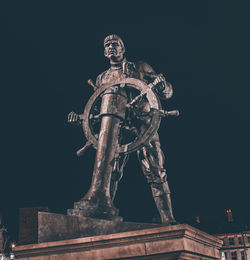 Low angle view of statue against sky at night