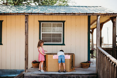 Brother and sister reaching for fresh watermelon at local farm market