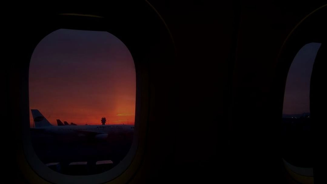 sunset, sky, window, mode of transportation, transportation, air vehicle, airplane, silhouette, nature, indoors, vehicle interior, transparent, orange color, no people, travel, glass - material, arch, architecture, dark, built structure