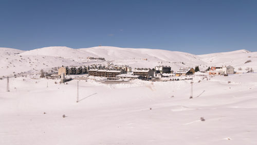 Houses on snow covered land against sky