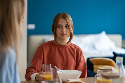 Portrait of young woman sitting on table