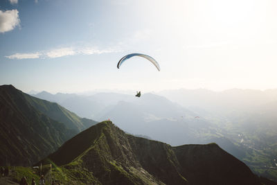 Person paragliding against sky